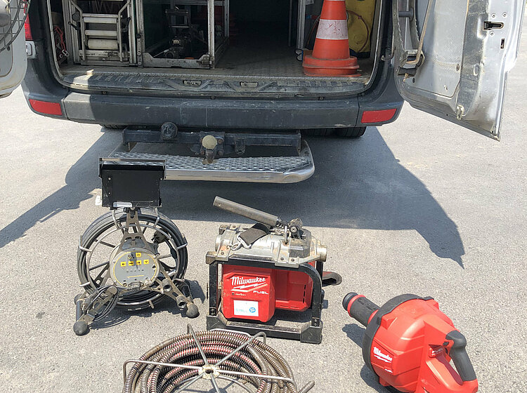 Offenes Auto mit Materialien und Equipment für die Rohrreinigung